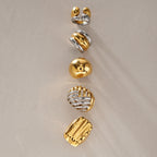 Five sculpted rings with gold and silver tone surfaces