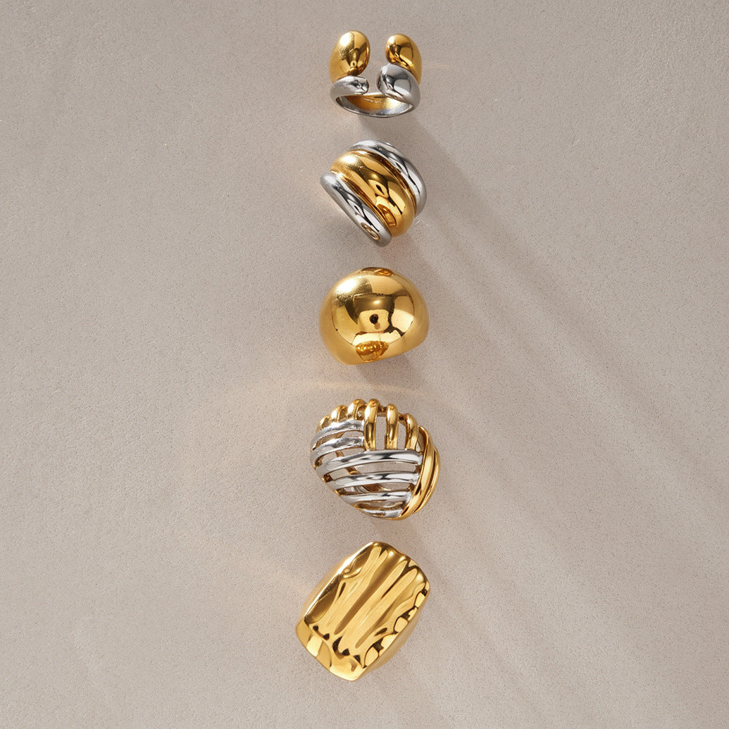 Five sculpted rings with gold and silver tone surfaces