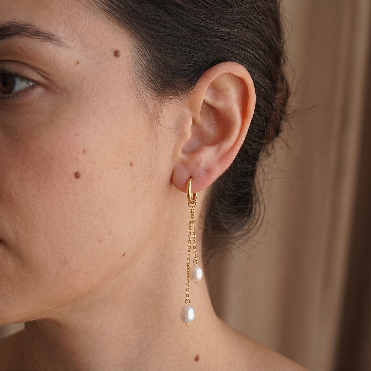 Double-chain white-drop hoop shown on the ear