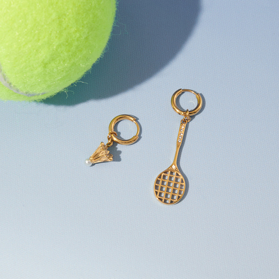 Sport charm earrings beside a ball