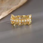 front view of wide pearl ring with ornate open scrollwork