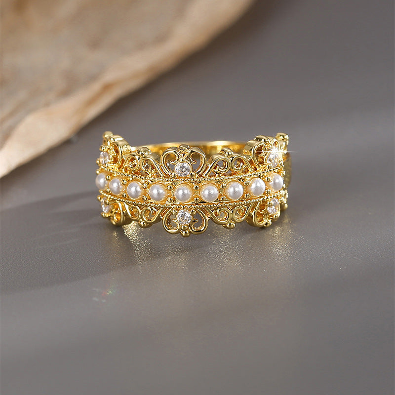 front view of wide pearl ring with ornate open scrollwork