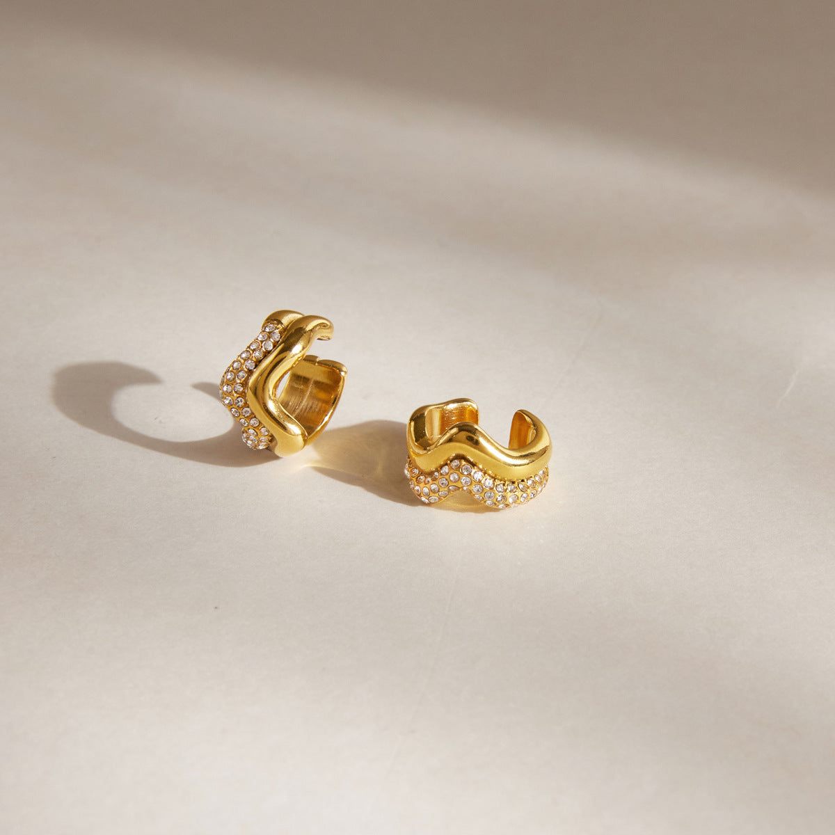 Wavy gold tone ear cuffs with clear stone rows