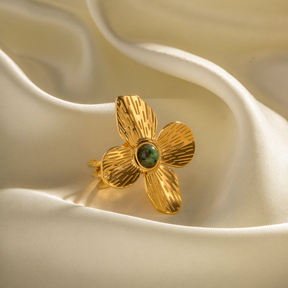 Gold plated flower open ring with green accent close-up