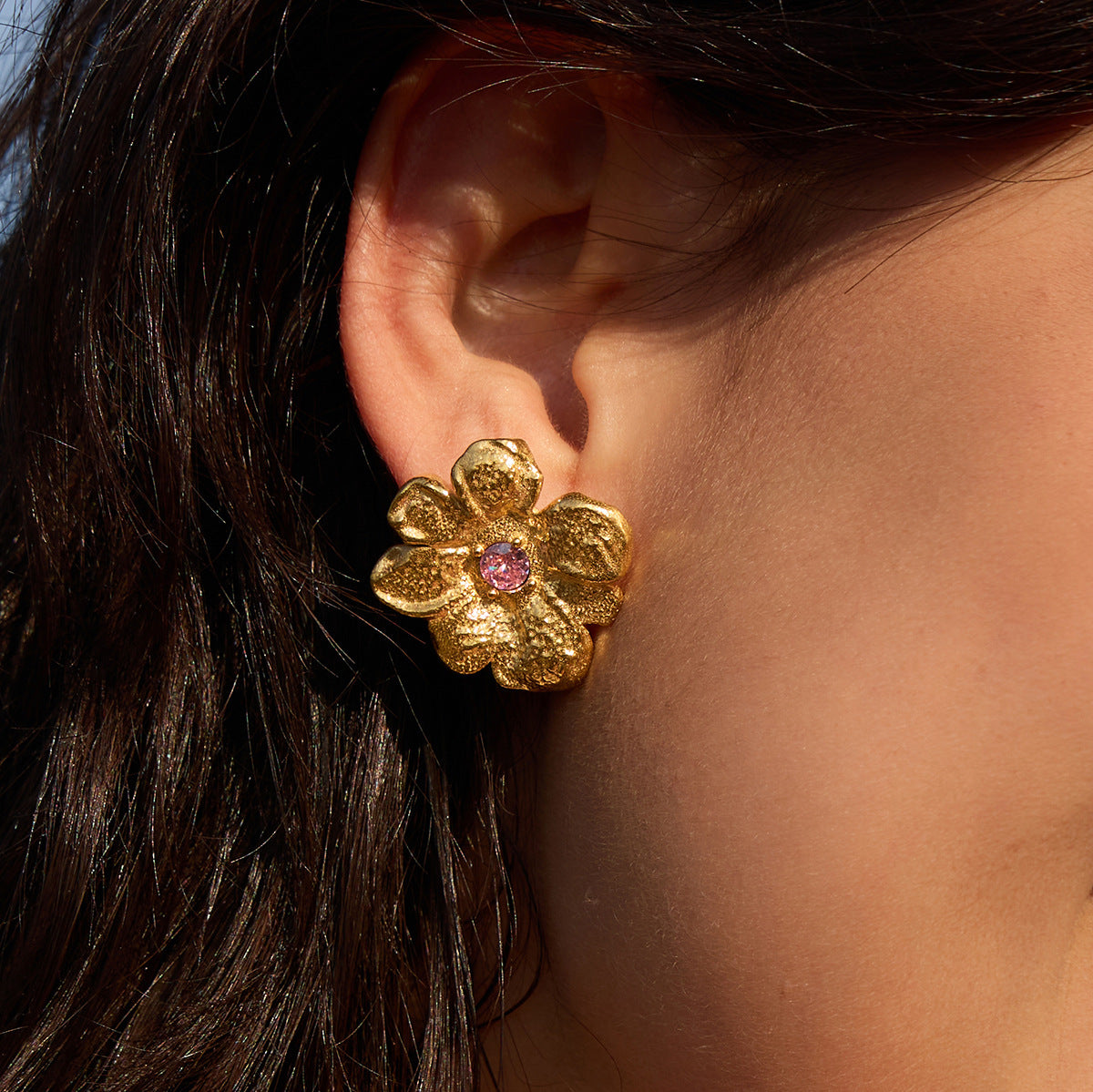 Pink-center flower stud worn close-up