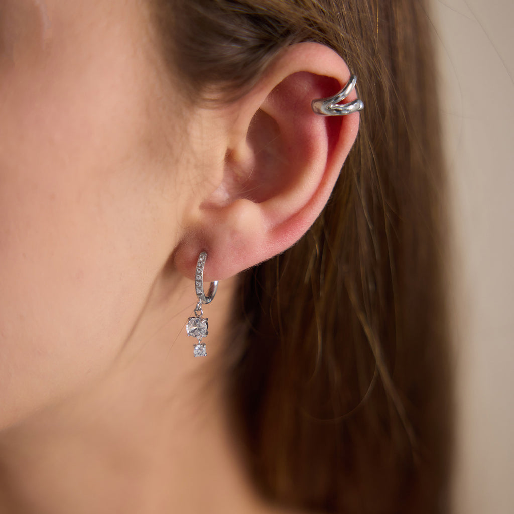 Silver tone clear stone hoop worn with a separate cuff