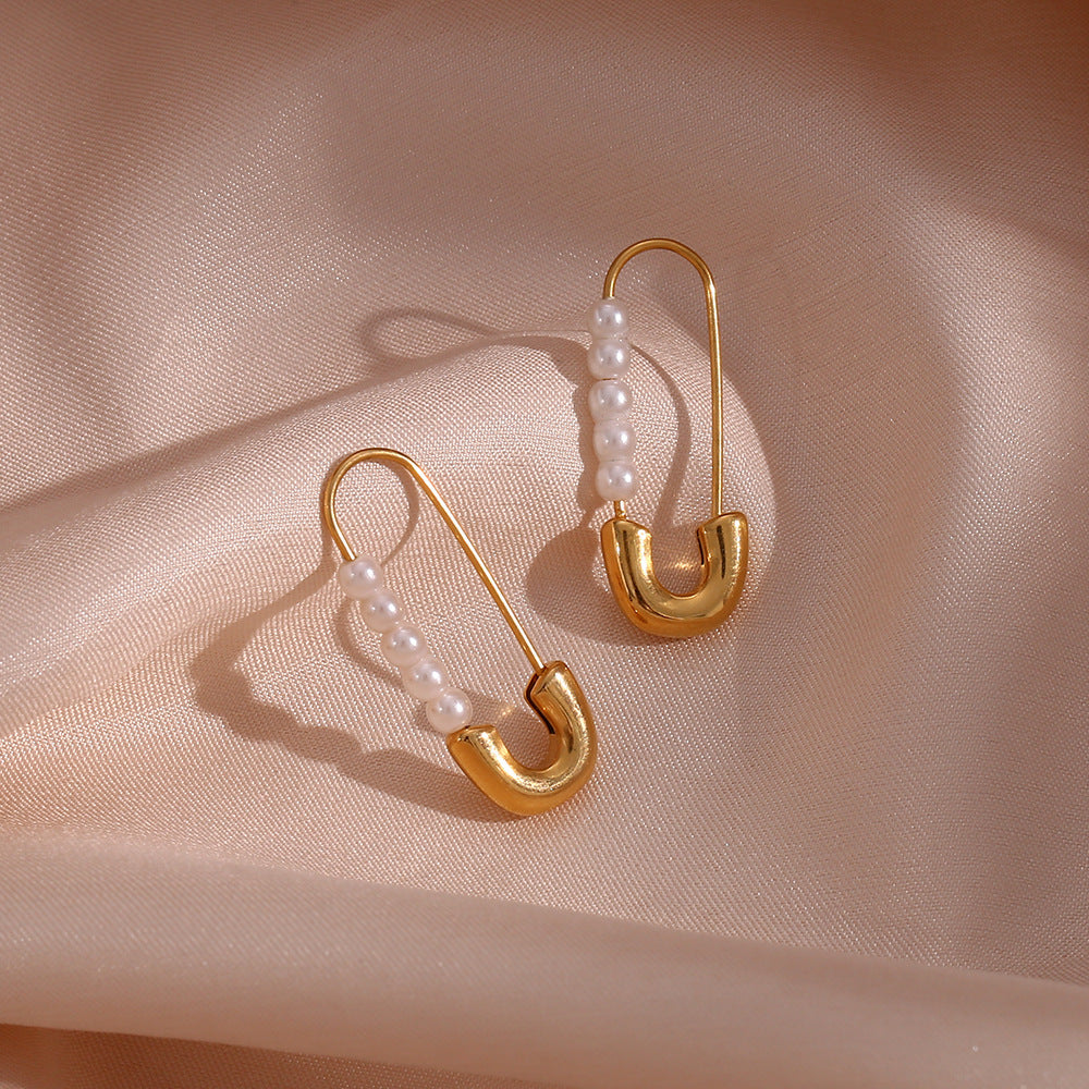 Gold-tone safety pin earrings with white imitation pearls on satin