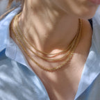 Separate gold tone necklaces styled in layers
