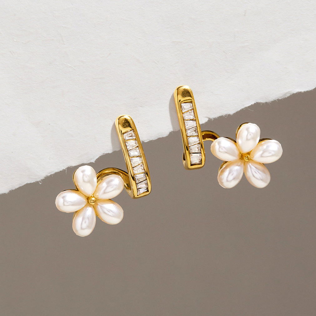 Resin pearl flower studs beside narrow clear accent curves
