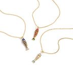 Fish pendant necklaces with colored detailing on white