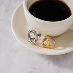 Open oval rings beside a cup