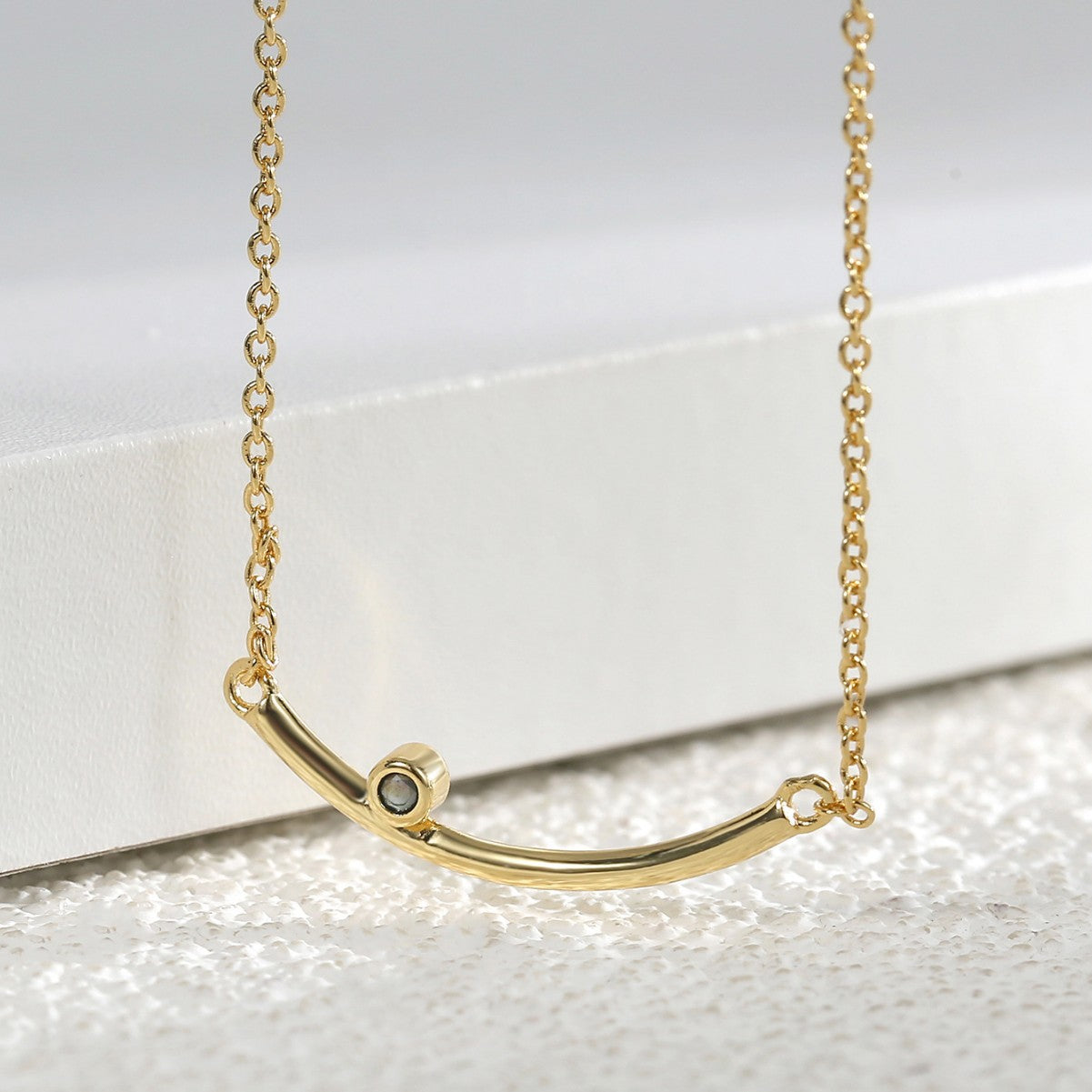 angled detail of the minimalist curved bar necklace