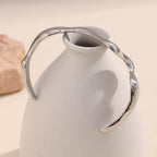 rear view of the silver-finish sculptural wave open cuff