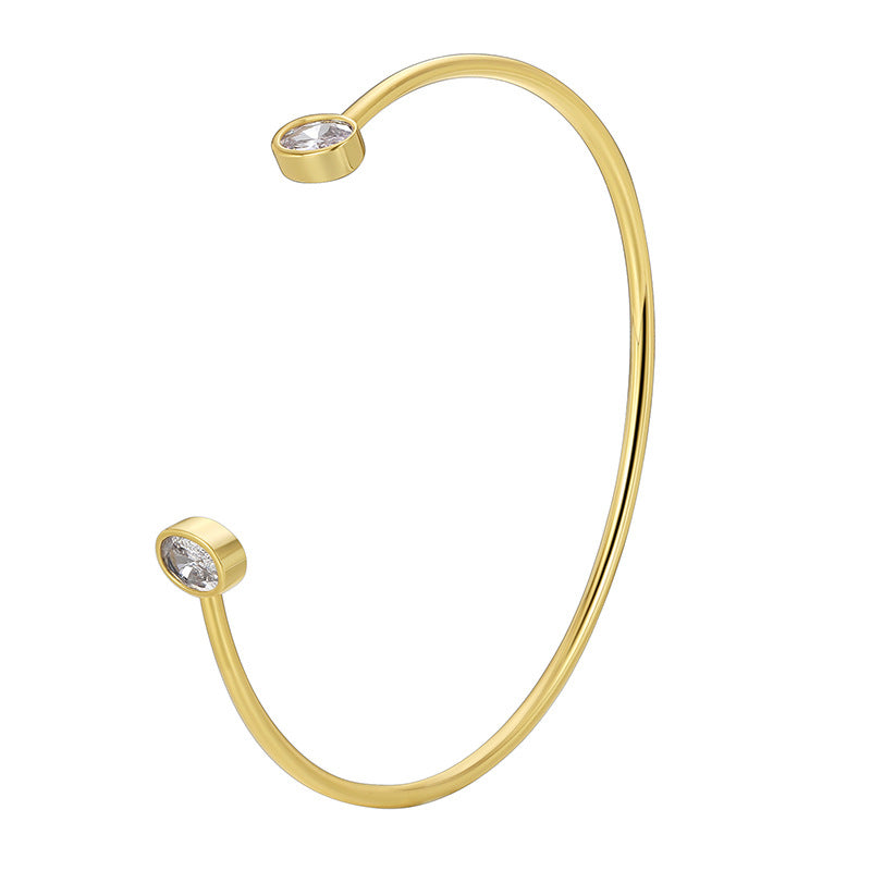 isolated gold plated cuff with bezel-style clear stone ends