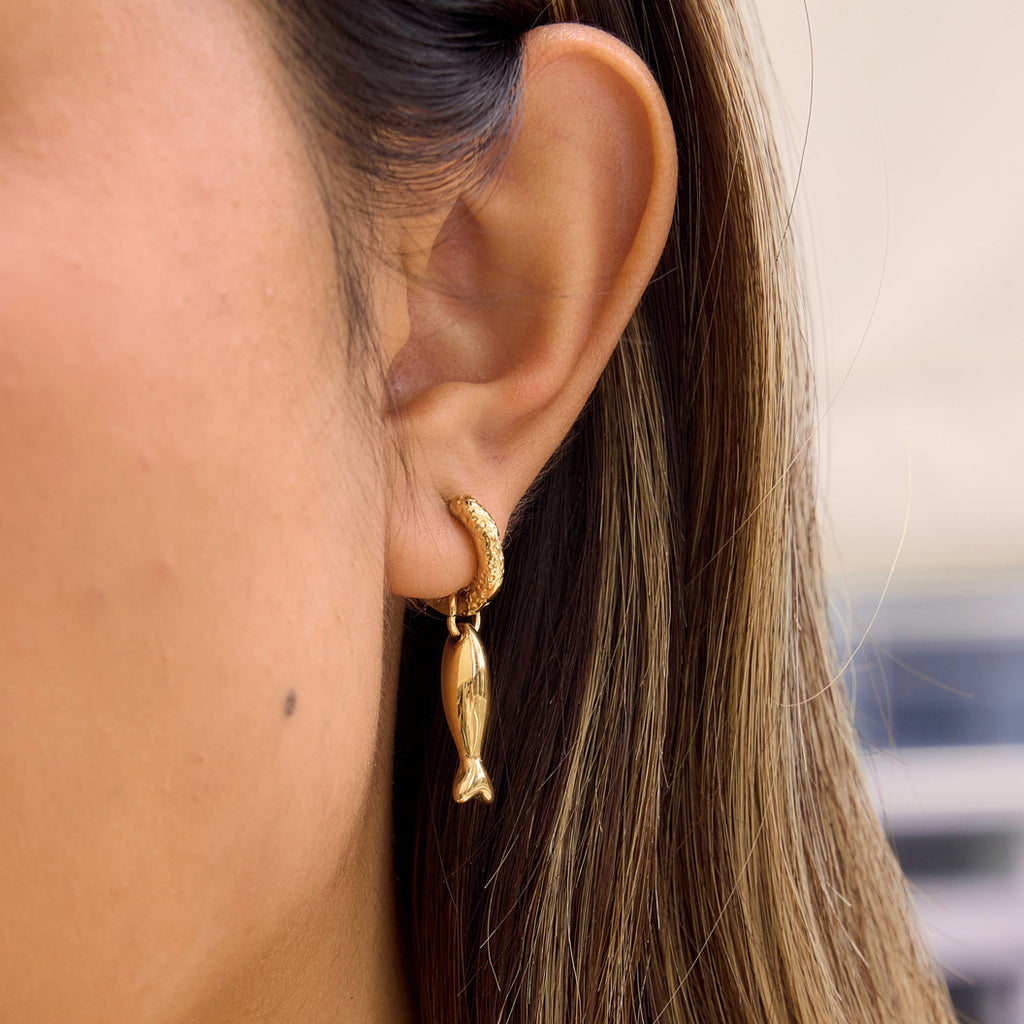 Polished fish drop shown on ear in profile