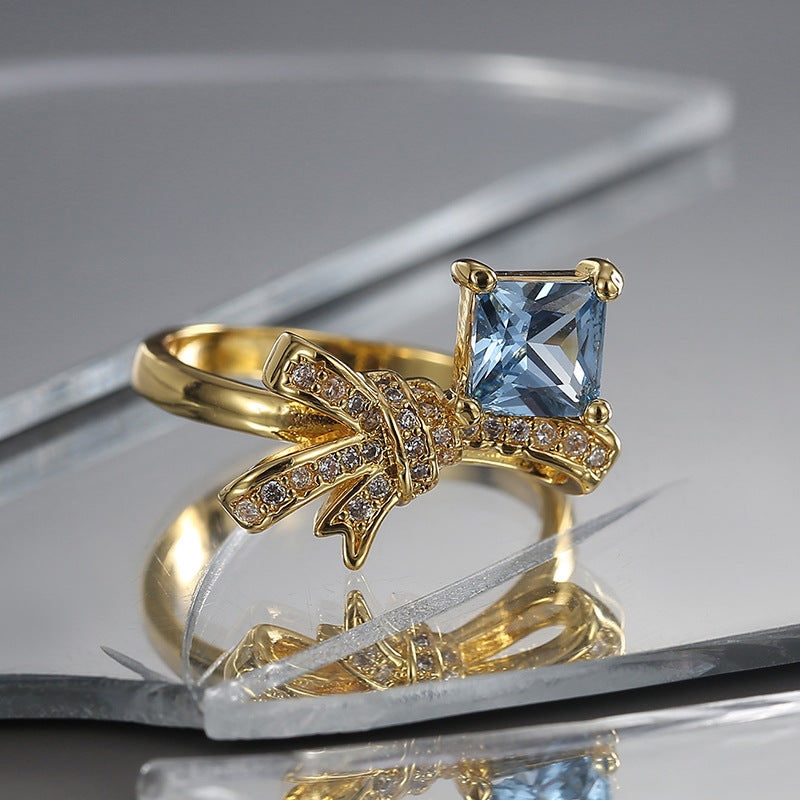 front angle of gold plated bow ring with clear accent rows