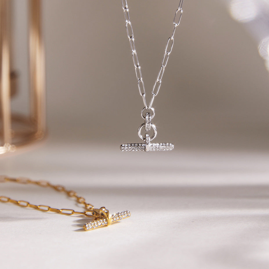 Pave T-bar pendant hanging above gold version