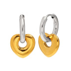 Gold tone heart charms hanging from silver tone hoops