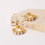 18 and 22 mm pearl-set open hoop earrings on pale stone