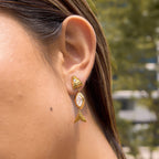 Clear marquise fish earring shown on ear outdoors