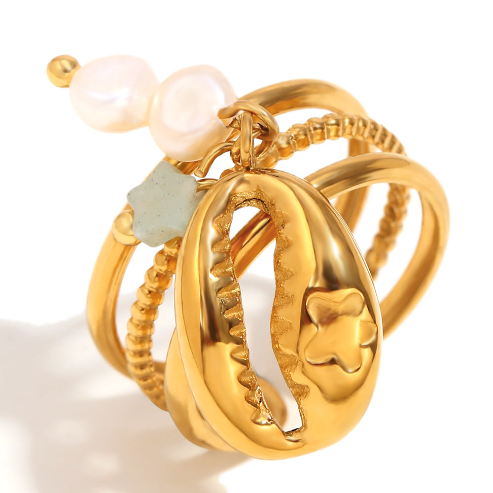 close view of the dangling cowrie-shell charm and pearl cluster