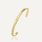 gold plated butterfly open cuff bracelet on a neutral background