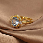blue oval zirconia ring displayed on folded brown satin