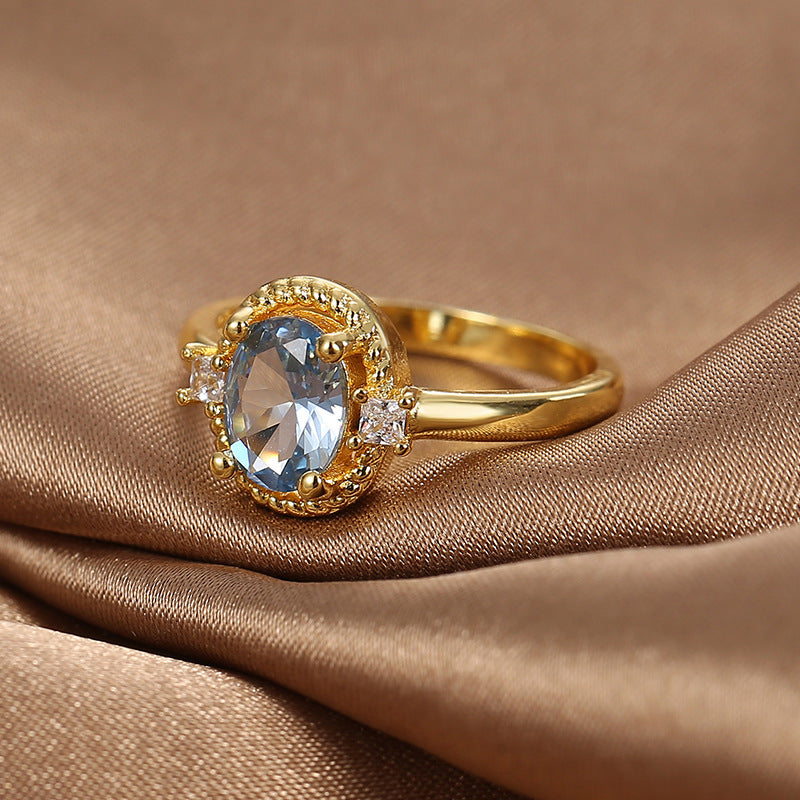 blue oval zirconia ring displayed on folded brown satin