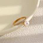 Ring showing offset pearl-look bead beside a white dish