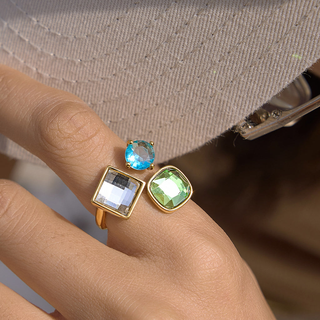 Clear square blue round and green stone ring on hand