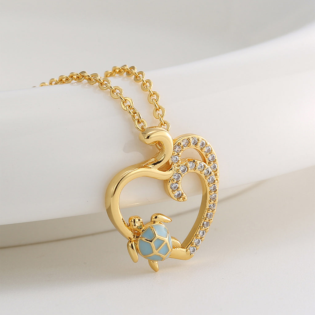 angled close view of blue resin turtle and open heart pendant