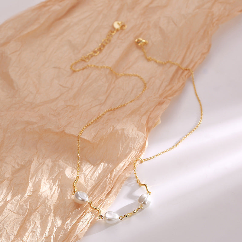 shell pearl necklace laid flat on textured fabric