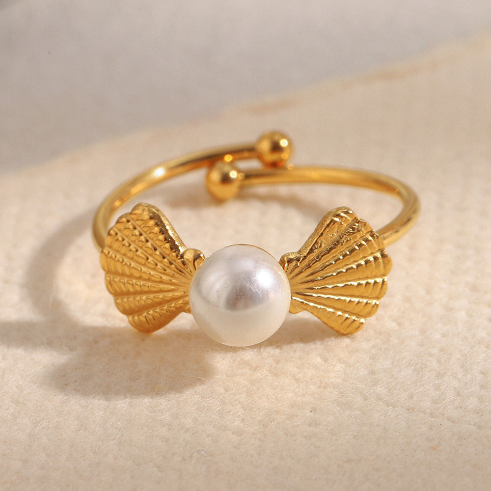 front view of ribbed shell motifs around an imitation pearl