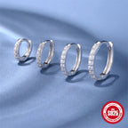 four silver-finish moissanite huggie sizes on blue fabric