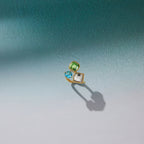 Geometric three-stone ring displayed on a pale surface