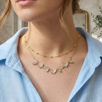 Clear stone butterfly row necklace layered with a separate chain