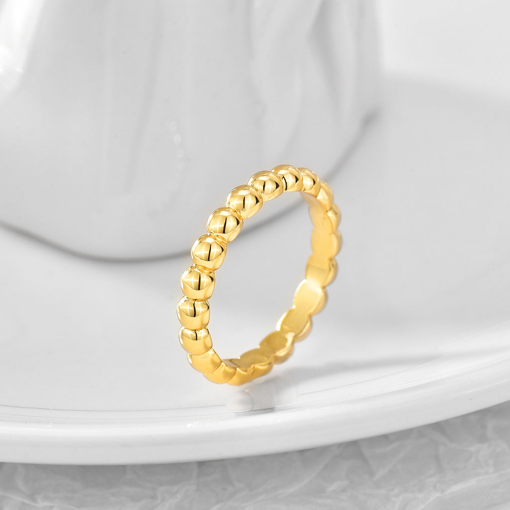 textured round bead ring displayed on a pale ceramic surface