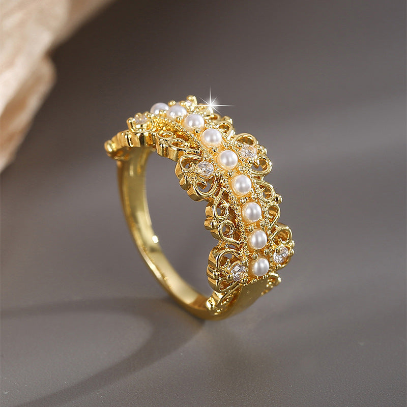angled gold plated cocktail ring with pearl rows and curling metal detail