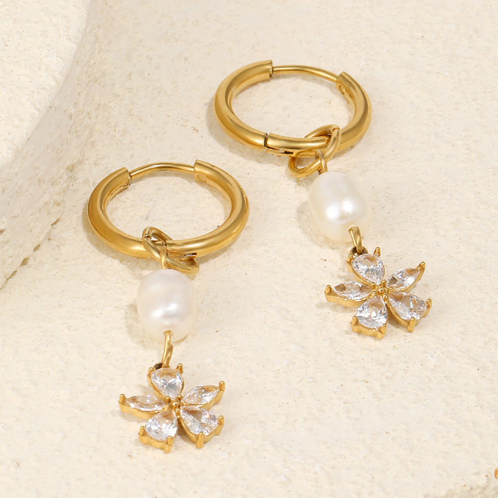stainless steel pearl flower huggie earrings styled on stone