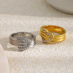 gold plated and silver-finish heart rings on a stone surface