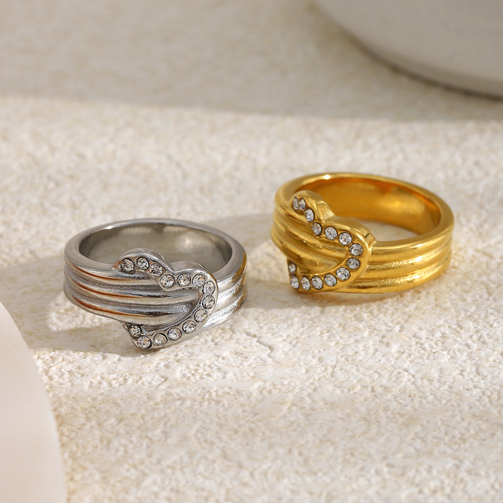 gold plated and silver-finish heart rings on a stone surface