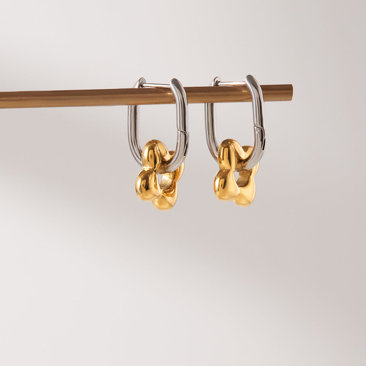 Two-Tone Floral Charm Stainless Steel Huggie Earrings — paired earrings on a neutral surface