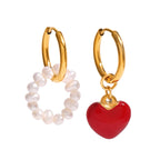 isolated gold plated heart and pearl-style bead huggie earrings