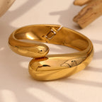 gold plated stainless steel twin snake-head hinged bangle in styled close-up
