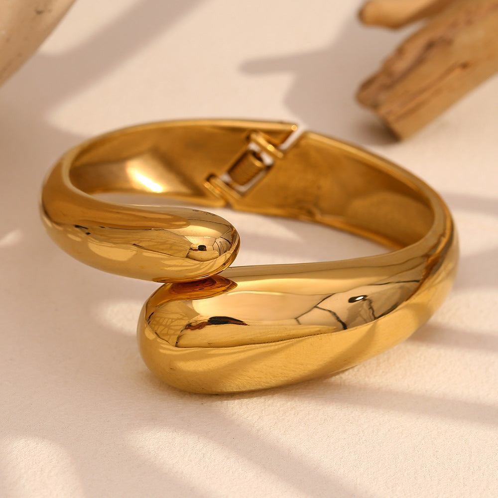 gold plated stainless steel twin snake-head hinged bangle in styled close-up