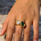 Green pear and clear oval ring shown on hand