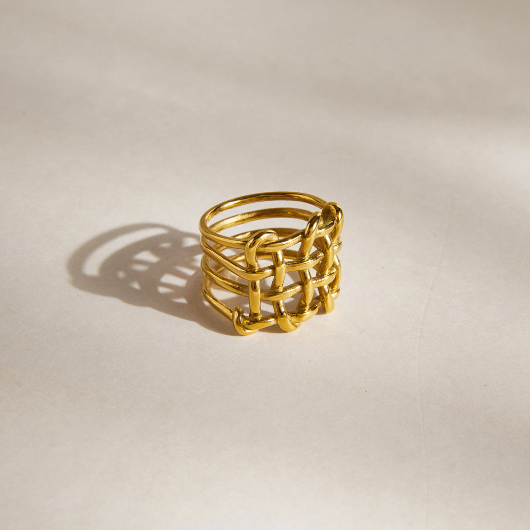 Gold tone woven lattice ring on a light surface