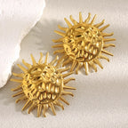 gold plated hammered sunburst statement stud earrings on a neutral surface