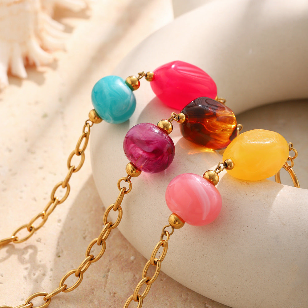 Close-up of contrasting resin bead pairs and gold tone links