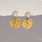 Angel heart medallion earrings hanging below clear heart studs